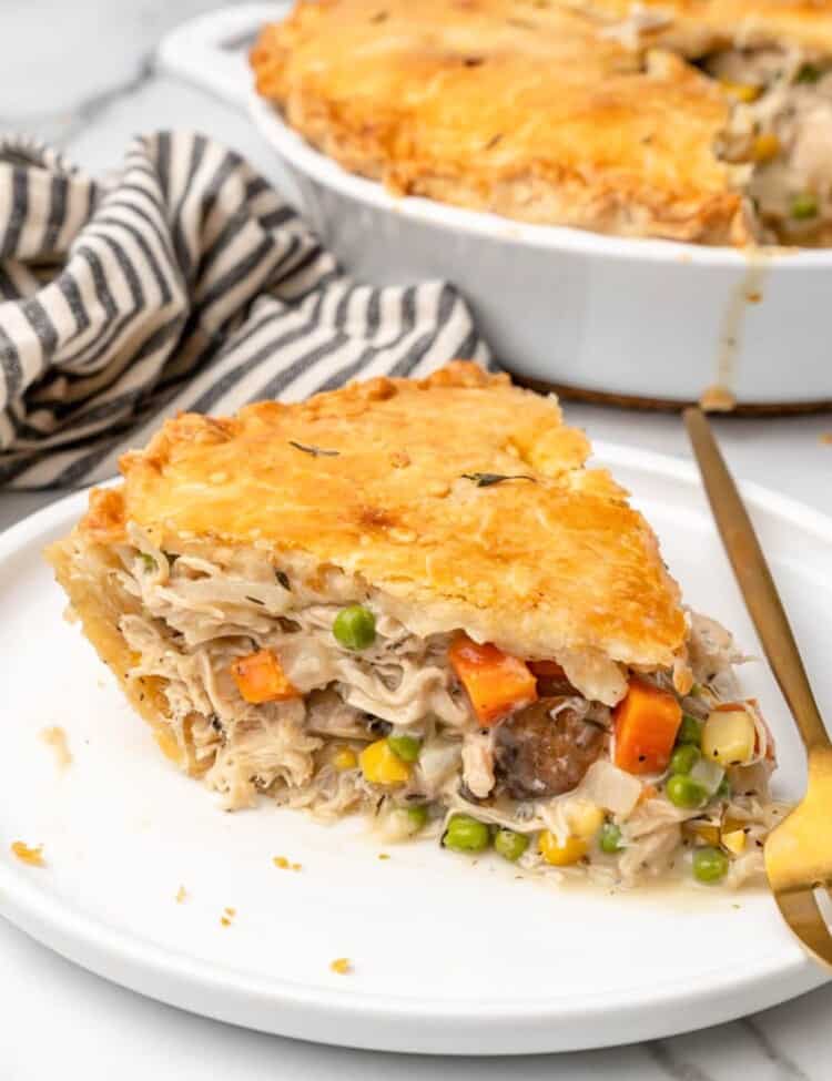 a wedge shaped slice of homemade chicken pot pie on a plate.
