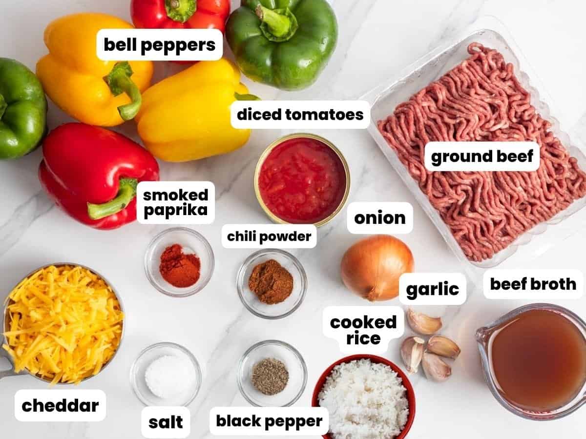 A pound of ground beef, a pile of bell peppers, and the ingredients needed to make slow cooker stuffed peppers.