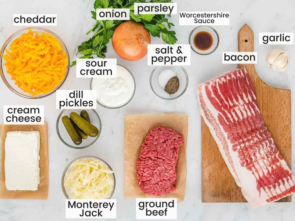 Ingredients needed for making cheeseburger dip including ground beef, bacon, cheeses, yellow onion, cream cheese and more.