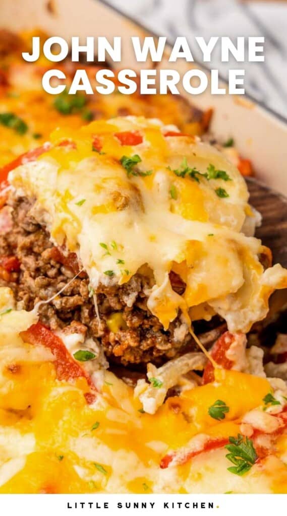a square of layered john wayne casserole with ground beef and cheese, being lifted out of the dish with a spatula