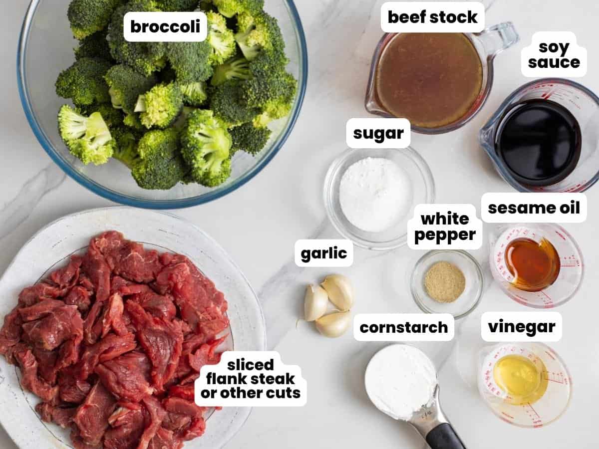 Ingredients needed to make beef and broccoli in a slow cooker, including sliced flank steak, broccoli, stock, and seasonings.