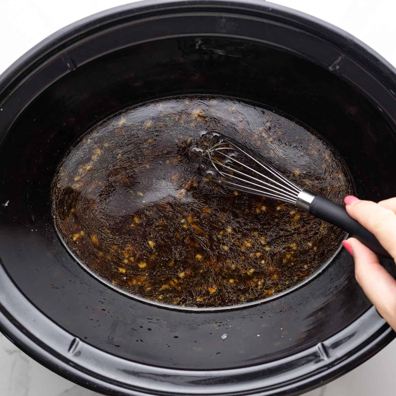soy sauce, broth and garlic mixed in a slow cooker for beef and broccoli.