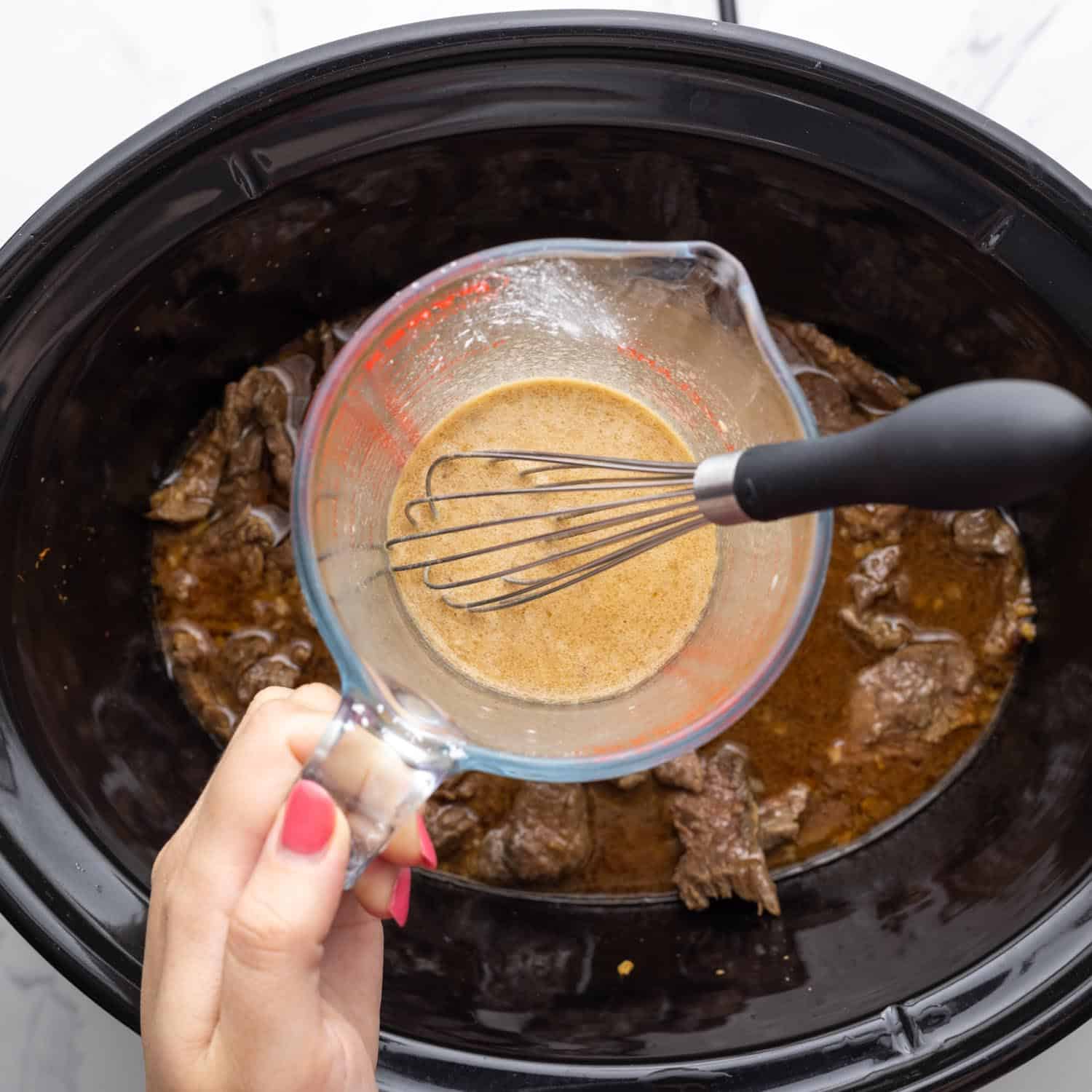 a slurry of cornstarch added to slow cooked beef slices.