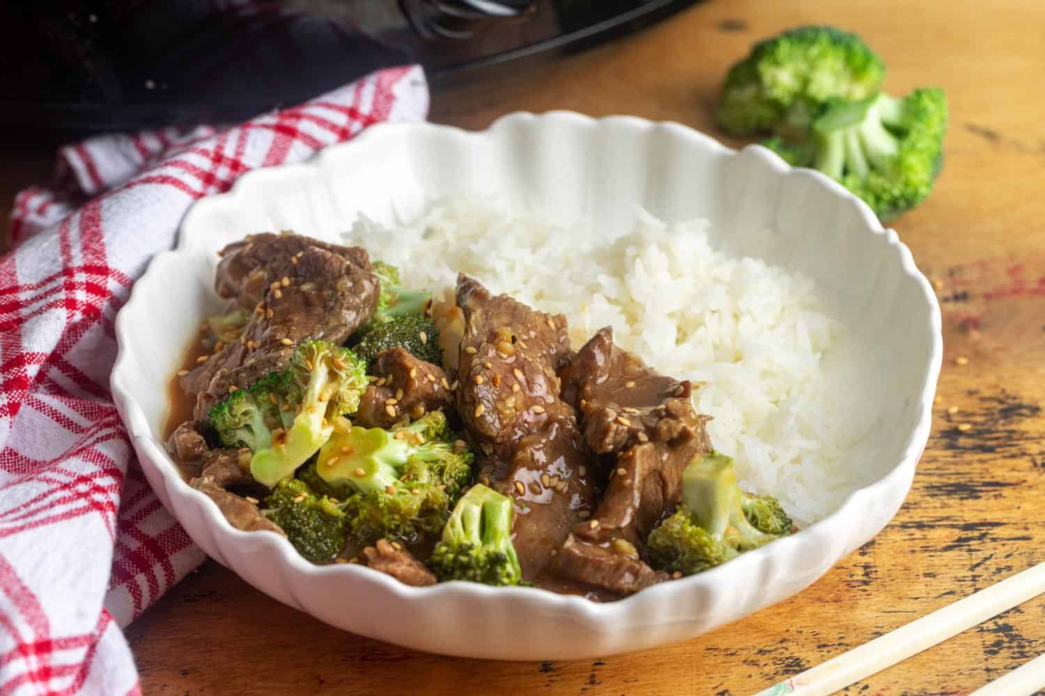 A bowl of beef and broccoli served with white rice