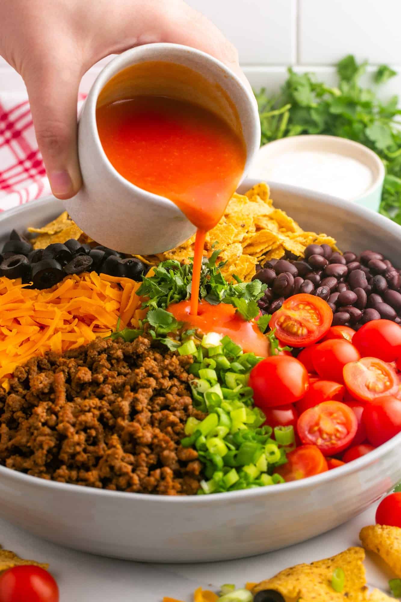 Drizzling catalina dressing over the taco salad