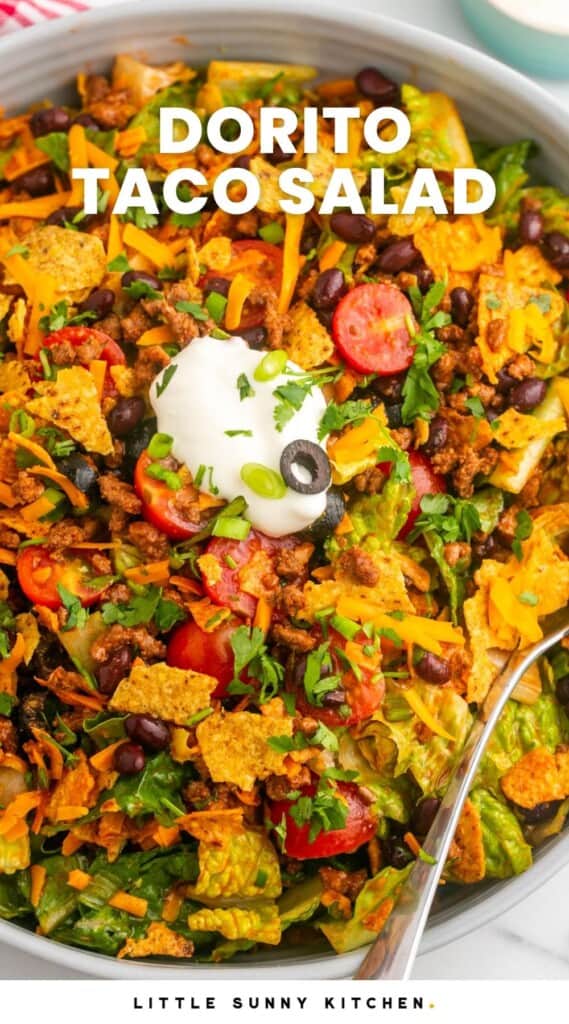 Overhead shot of dorito taco salad in a large salad bowl. With overlay text that says "Dorito Taco Salad"