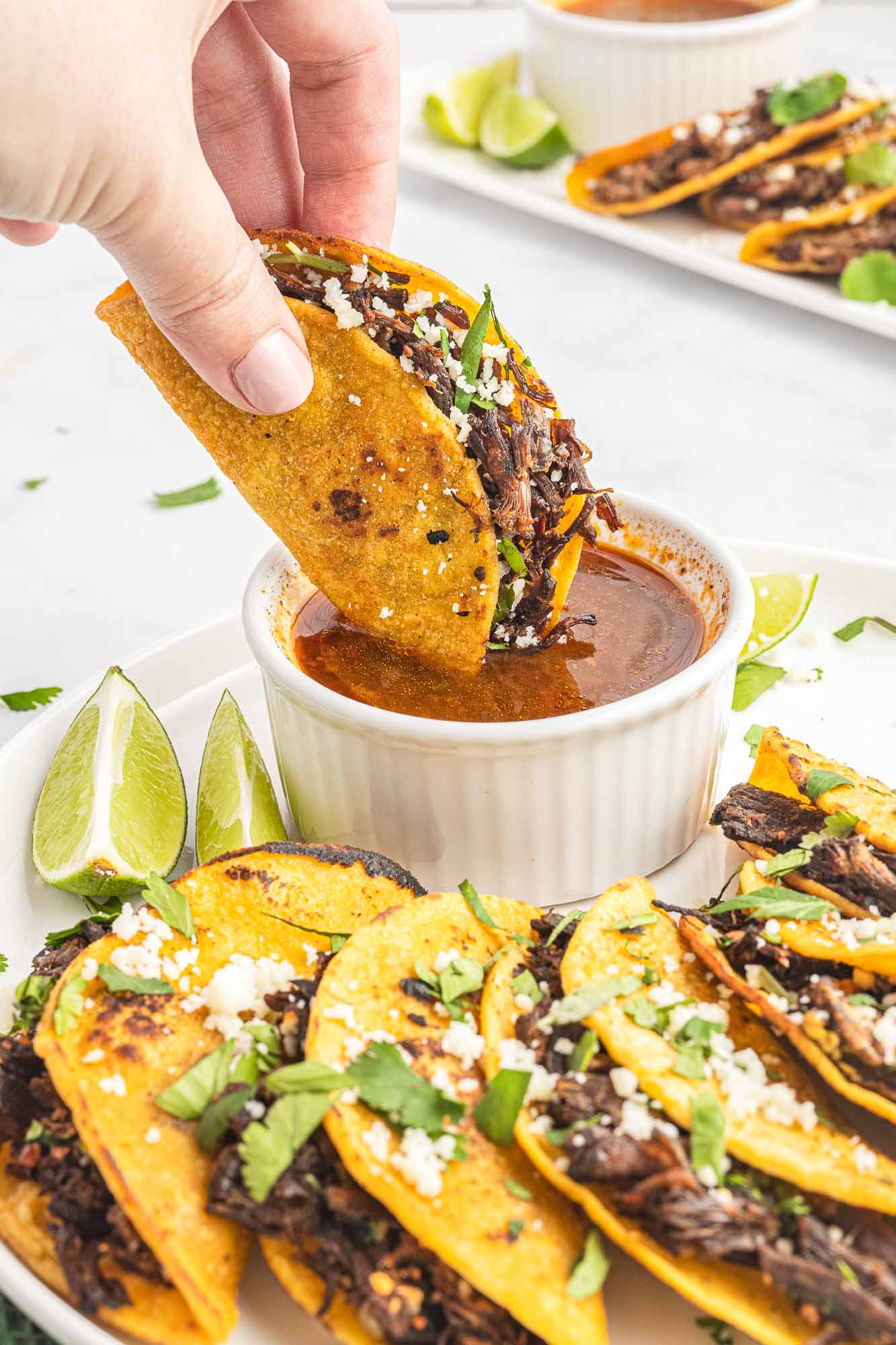 Dipping birria taco in sauce